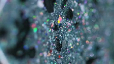 Dikey video. Parlak bir dökülme. Sıvı sim dokusu. Bulanık deniz mavisi siyah holografik pullar yağlı boya damlaları soyut sanat arkaplanı ve bokeh ışıkları.