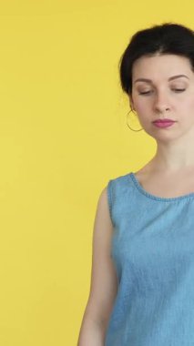 Dikey video. Neşelen biraz. Beklenmedik bir hediye. Kese kağıdında hazır bulunan üzgün kadın mutlu, mutlu, minnettar yüz ifadesi sarı boş alanda izole edilmiş..