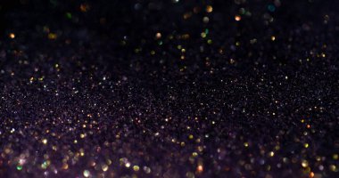 Kıvılcım dokusu. Parlak bokeh. Odaklanmamış sarı mor renkli görkemli işaret fişeği koyu siyah soyut sanat üzerinde yüzen yuvarlak parıltıyı süsler..