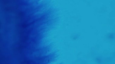 Parlayan sıvı. Yapışkan damlalar. Parlak mürekkep dokusu. Odaklanmamış parlak mavi renk parıldayan boya karışımı dalga hareketinin soyut sanat arkaplanı.