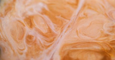 Dalgalı boya. Parlak sıvı. Bulanık altın sarısı beyaz mermer desenli kimyasal sıvı akrilik soyut arkaplanda yayılıyor.