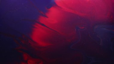 Mürekkep sıçradı. Karışık renk. Odaklanmamış kırmızı kestane rengi, mor, sıvı, sıvı, akrilik, kabarcık, soyut, siyah arkaplan üzerinde yüzer..