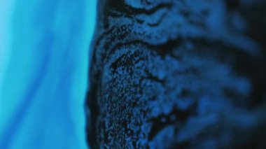 Güzel çizim. Parıltılı boya karışımı. Mermer dokusu. Odaklanmamış mavi beyaz renk. Işıl ışıl mürekkep katmanları koyu soyut sanat arka planında hareket ediyor..