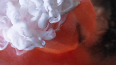 Pürüzsüz sis. Boya spreyi. Beyaz mürekkep dumanı portakal rengi pırıltılı elmasa damlıyor. Renk pigmentleri soyut bulanık arkaplan dökülüyor.