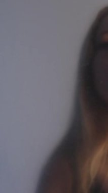 Dikey video. Kadın kederi. Özgürlük arzusu. Kırışık şeffaf polietilen filmin arkasında sıkışmış rahatsız bir kadın..