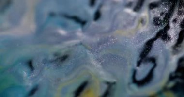 Köpüklü sıvı. Mermer sanat. Soyut koyu arkaplan üzerine dökülen su karışımında çözünmüş sarı renkli parlak boya..