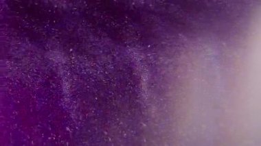 Görüntü parlıyor. Işıltılı akış. Beyaz ışıl ışıl şeffaf toz, parlak su sıçratır soyut bokeh açık mor çok renkli arka planda hareket eder.