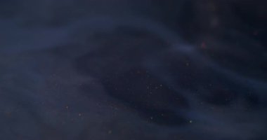 Renk dalgalanması mürekkebi. Su altı dokusu. Bulanık mavi neon parlak su kimyasal parçacıkları soyut koyu siyah arkaplan üzerine dökülüyor.