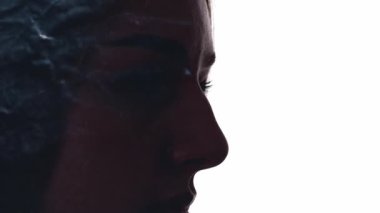 Aydınlanma enerjisi. Ruhsal iyileşme. İç huzuru. Etkilenen kadın, beyaz boş arkaplanda izole edilmiş parlayan tozla çifte maruz kalmış siluetle karşı karşıya.