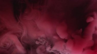 Duman sıvısı. Mürekkep sisi. Pembe kırmızı renk akışı fantezi pigmenti çözünmüş su siyah sanat soyut mistik arka planda çözünür.