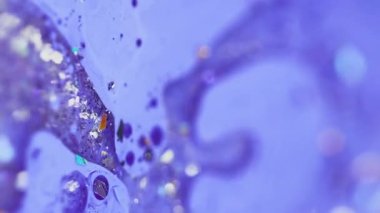 Dikey video. Sıvı boya karışımı. Köpüklü yağ damlası. Odaklanmamış mor renkli parlak parçacıklar akrilik akrilik sıvı mürekkep sızıntısı soyut sanat arka planı ve bokeh ışıkları..