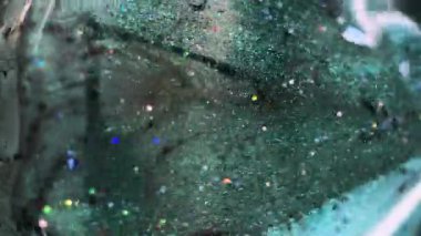 Dikey video. Parlak sıvı damlası. Işıldayan boya. Bulanık yeşil renkli pullu partiküller sıvı ıslak parlatıcı elmas hareketli elmas şekilli soyut sanat arkaplanı ve bokeh ışıkları.