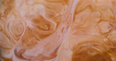 Dalgalı boya. Parlak sıvı. Bulanık altın sarısı beyaz mermer desenli kimyasal sıvı akrilik soyut arkaplanda yayılıyor.