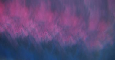 Sisli doku. Odaklanmamış duman moru. Yanıp sönen renkli su bulanık koyu soyut aydınlık arka planda uçuyor..