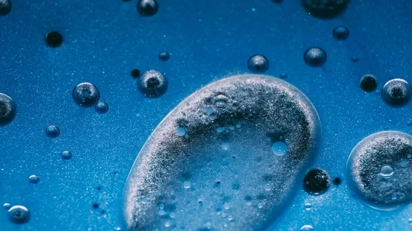 Yağ sanatı. Boya karışımı. Odaklanmamış mavi mürekkepli su kabarcıkları sıvı esansı yuvarlar sıvı soyut yaratıcı arka planda yüzer.