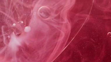 Mürekkep lekesi. Duman girdabı. Bulanık kaos, kırmızı pembe boya pigmenti suyunu harmanlıyor. Parıldayan toz parçacıkları desen buhar soyut arkaplan yayıyor.