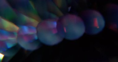 Parlak daireler. Bulanık yuvarlak işaret fişeği. Odaklanamayan neon ışıklı gözlük mercek dokusu soyut koyu siyah arkaplanda titreşiyor.