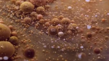 Emülsiyonu bırak. Akrilik kütle. Sarı kahverengi boya ile şeffaf doku sıvısı tüttürmek parçacıkların etrafında patlamış sanat tozu soyut arka plan.