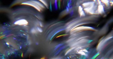 Işık daireleri. Bulanık gökkuşağı çizgileri. Odaklanamayan yeşil turuncu mercek soyut koyu siyah arkaplan üzerindeki kaleydoskop spektrumunu parlatmaktadır..