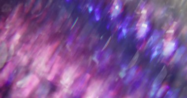 Mercek parıldıyor. Parıldayan kaleydoskop çözüldü. Bulanık soyut bokeh ışık arkaplanı üzerinde dönen mor mavi yanıp sönen sıvı.