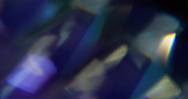 Işık huzmesi. Bulanık gökkuşağı lensi. Odaklanamayan sarı mor çok renkli desen, soyut sanatın koyu siyah arka planında parıldıyor..