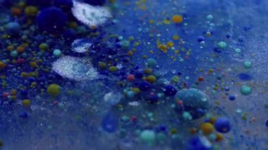 Parıltı dökülüyor. Mürekkep patladı. Kabarcık jeli boyası mavi renkli parlak suda çözünür. Yaratıcı sıvı karışımı soyut arka plan köpük dokusu.