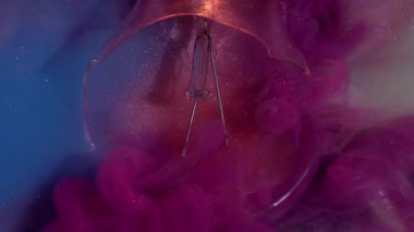 Mürekkep sisi. Akış patladı. Pembe dumanlı dalgalı bulut bulanık sisli mavi yüzey üzerine dökülüyor su zarar görmüş ampul soyut arka plan.