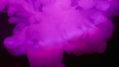 Neon dumanı. Hipnoz sıvısı. Mor pembe menekşe sanat eserleri siyah gecenin üzerine dökülüyor soyut arkaplan parıldıyor. Gökkuşağı kiriş su lensi.