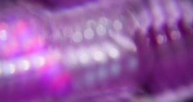 Optik sızıntı. Bulanık şafak parlıyor. Soyut ışık arkaplanına yayılan sönük mor gökkuşağı spektrumu yanıp sönen mercek..