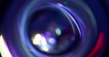 Çember ışığı. Bulanık ışık saçıyor. Soyut sanat eserleri üzerinde sönük mor kırmızı yanıp sönen mercek dokusu koyu siyah arkaplan.