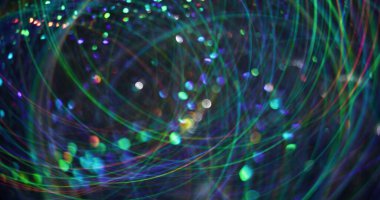 Odaklanamayan parlayan titreşim. Işıl ışıl parlıyor. Renkli, parlak, parlak, güzel parçacıklar soyut, bulanık bokeh ışık arka planında mercek parıltısı hareketi.