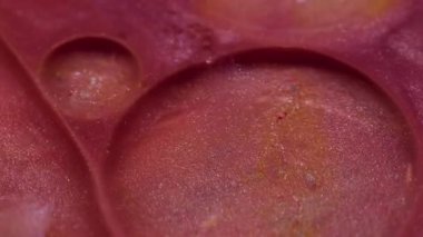 Köpüklü sıvı. Yağ kabarcıkları. Pembe, pırıl pırıl parlayan dokudan oluşan büyük yuvarlak yüzey. Hipnotik karıştırıcı sanat malzemesi soyut arkaplan.