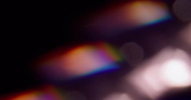 Parlak renk. Bulanık sanat ışığı. Odaklanmamış mavi yeşil parıltı gökkuşağı spektrum kıvılcımları koyu siyah arkaplanda yüzüyor..