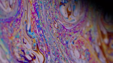 Benzin gökkuşağı. Sıvı çok renkli. Odaklanmamış mor turuncu, mavi, turuncu, sıvı yağ eğrisi koyu siyah, bulanık ışık, soyut sanat arka planında akrilik kaygan..