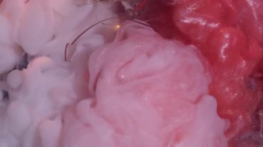 Duman patlaması. Boya karışımı. Parlak turuncu mat beyaz sanat sıvısı akıntıları. Siyah arka planda kırık ampul üzerine çakışan bulutlu mürekkep spreyi.