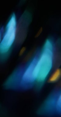 Işık parlıyor. Bulanık işaret fişeği. Odaklanmamış mavi sarı renkli mercek soyut koyu siyah arkaplan üzerinde ışıltı dokusu.