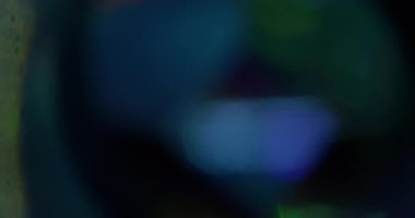 Soyut işaret fişeği. Bulanık renkli parıltı. Odaksız mavi yeşil lens dokusu. Sanatın karanlık arka planında sihirli ışık parıltısı..