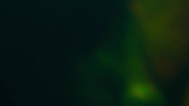 Işık bulanıklığı. İşaret fişeği soyut. Işıldayan sarı turuncu mavi çok renkli parlak yanıp sönen ışıklar karanlık sanat arka planında hareket ediyor..