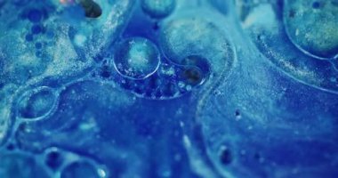 Parlak kabarcıklar. Odaklanmamış parlaklık rengi. Mavi yanıp sönen parlak boya sıvısı soyut bulanık bokeh ışığı modern arka planda hareket ediyor.