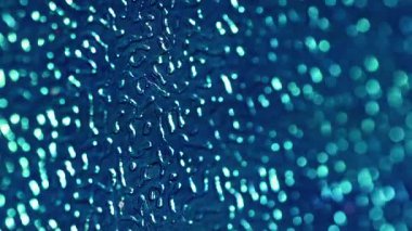 Bokeh kumaşı. Kabartmalı plastik yüzey. Mavi taneli yapay deri, değişen ışıklandırmalı dalgalı çarşaf. Dekoratif odaklanmış işaret fişeği arkaplanı.