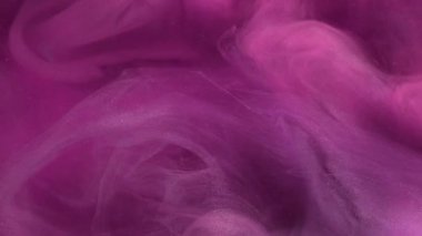 Parıltı akıyor. Sanat dumanı. Mor boya sıvısı dumanı ve parlak parçacıklar garip bir şekilde spiraller. Odaklanamayan pembe su soyut arkaplanındaki dalgalı peçe suluboya..