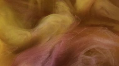 Duman sıvısı. Suluboya bulutu. Karanlık, gizemli ve soyut arkaplanda açık renkli mürekkep karışımı. Sarı mor boya sisi bulanık su dalgalarıyla parıldıyor..