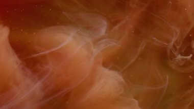 Bulut sıvısı. Boya dumanı. Pürüzsüz turuncu suluboya peçeler suda karışıyor. Soyut akış odaklanmış bulanık dokuya sahip gizemli renk arkaplanı.