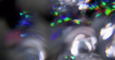 Kaleydoskop titreşiyor. Bulanık sihirli ışıltı. Odaklanamayan yeşil turuncu mercek soyut sanatın koyu arkaplan üzerindeki ışık çemberlerini yansıtıyor..