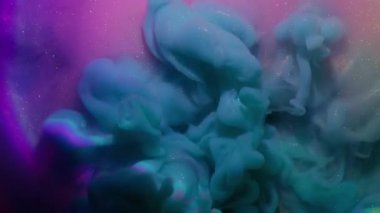 Duman girdabı. Parıldayan parçacıklar. Çok renkli sıvı yüzeyde mavi sisli boya patlaması. Gizemli su karışımı soyut arkaplan.