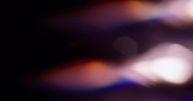 Parılda. Bulanık lazer. Soyut sanatın koyu siyah zeminine odaklanmış mavi yeşil çok renkli gökkuşağı spektrum ışığı.