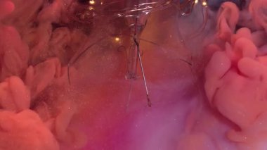 Çok renkli sıvı. Parlak duman. Işıldayan arka planda turuncu boya patlaması. Dalgalı karışım bulut parçacıkları kırık lamba.