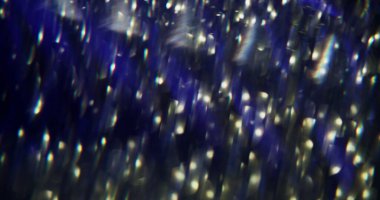 Parlayan kaleydoskop. Odaklanmamış işaret fişeği titreşimi. Yanıp sönen parlak mavi renkli mercek koyu siyah, soyut, aydınlık, modern arkaplanı aydınlatıyor..