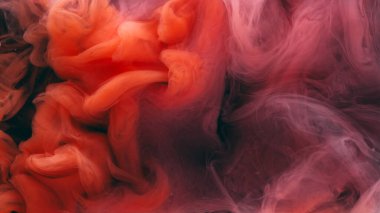 Renkli duman dokusu. Suyu boya. Odaklanmamış mor turuncu bulut sıçrama sıvısı soyut koyu siyah arkaplan üzerinde hareket ediyor.