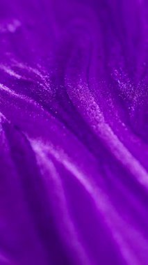 Dikey video. Islak, ışıldayan bir doku. Mürekkep damlası. Odaklanmamış neon rengi parlak parlak sıvı boya sızıntısı dalga hareketi soyut sanat arkaplanı.